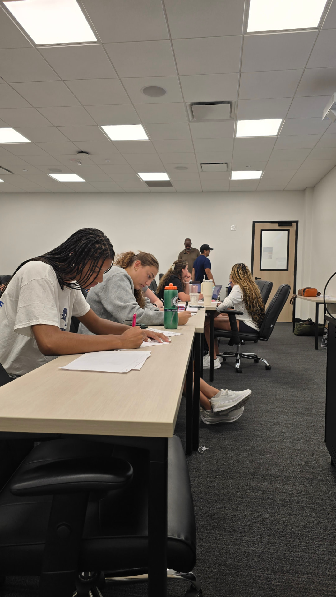 Student-athletes working through the WIN | WIN social impact NIL workbook in a team meeting room