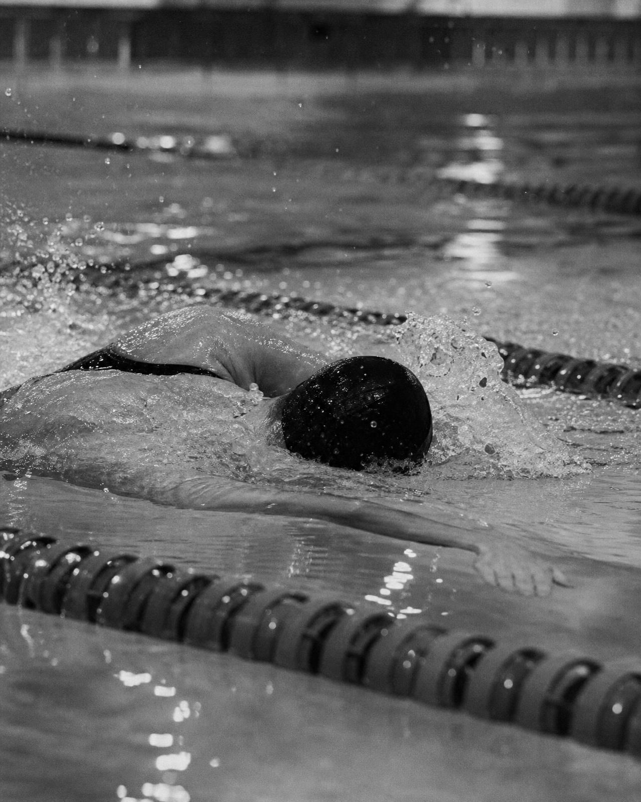 Swimmer mid-stroke in a lane, face down in the water